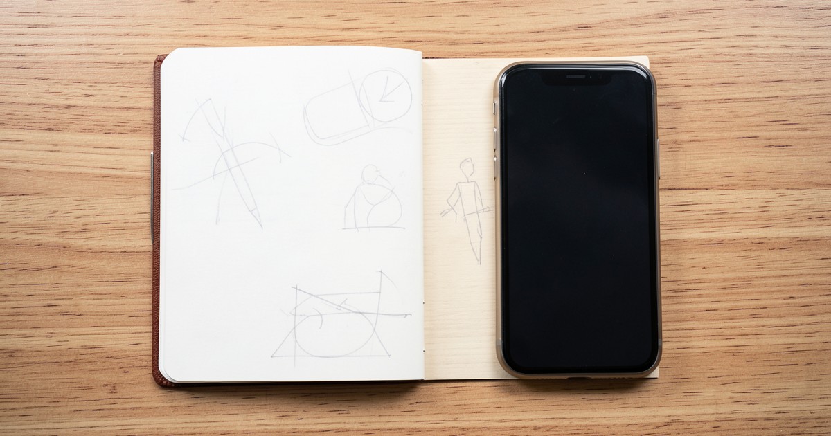 ノートとスマートフォンが置かれた机の上の、動画制作の企画構成をイメージさせる風景